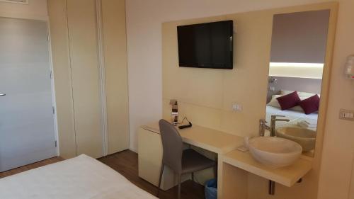 a room with a desk with a sink and a bed at Hotel De La Ville depandance di Hotel Augustus in Fano