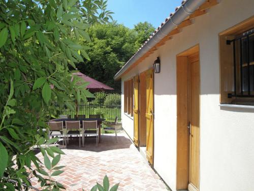 a patio with a table and chairs and a building at Nettancourt Family Stay in Revigny-sur-Ornain