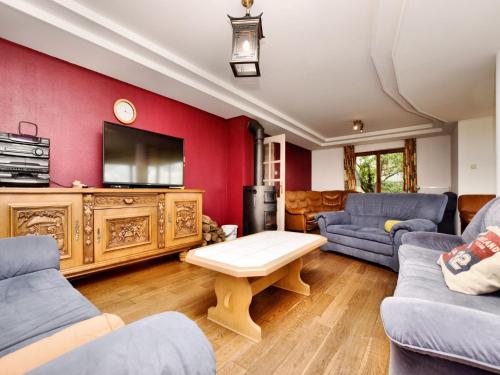 a living room with a red wall with a tv at Holiday Home in Schצnberg with Jacuzzi in Schoenberg