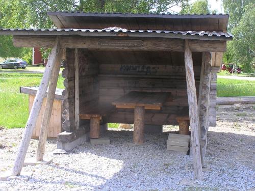 a wooden shelter with a bench in a park at Fredrika Hotell Jakt&Fiskecamp in Fredrika
