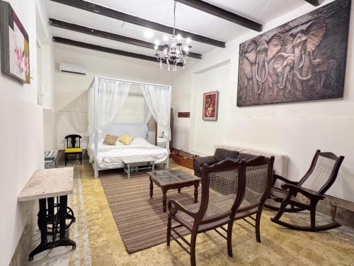 a living room with a bed and chairs and a couch at Casa Peregrina 613 in Mérida