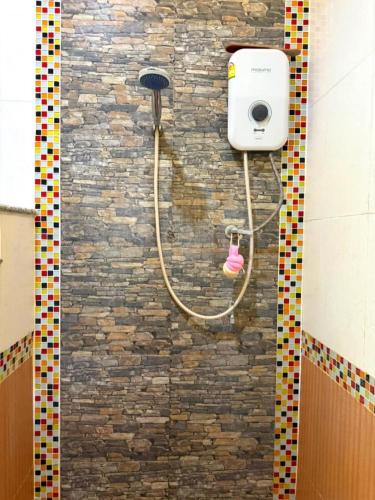 y baño con ducha y pared de ladrillo. en Green Heaven Bungalow 1, en Nathon Bay