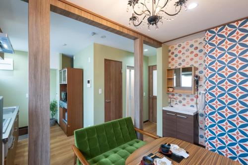 a living room with a green couch and a table at 長期ステイ歓迎 ポップ ディズニー風 TDR スカイツリー好アクセス 定員3名 東京駅10分 駐車場予約 送迎有 HOTEL DREAM MUSIC Tōyōchō japanese-pop in Tokyo