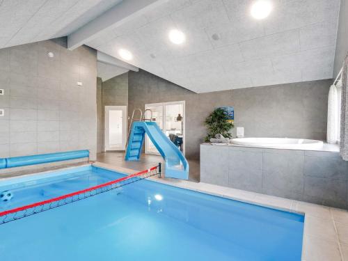 a large swimming pool with a slide in a bathroom at 5 star holiday home in Ringkøbing in Ringkøbing