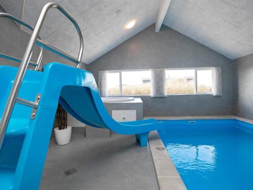 a indoor swimming pool with a blue slide at 5 star holiday home in Ringkøbing in Ringkøbing