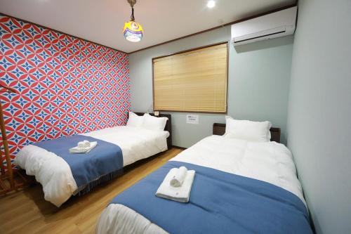 a room with two beds and a window at 長期ステイ歓迎 ポップ ディズニー風 TDR スカイツリー好アクセス 定員3名 東京駅10分 駐車場予約 送迎有 HOTEL DREAM MUSIC Tōyōchō japanese-pop in Tokyo