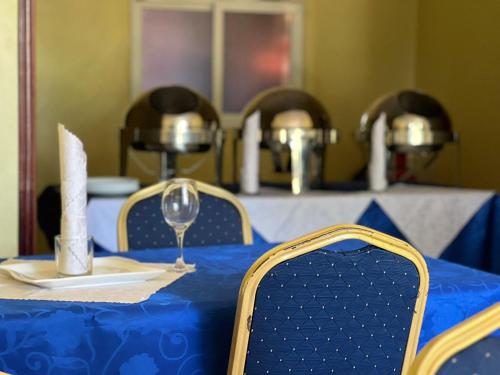 a blue table with chairs and a wine glass at Hotel Royal Nest Entebbe in Entebbe