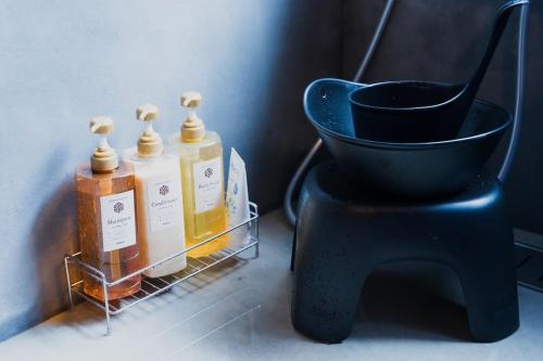 a black vase and some bottles on a shelf at 阿蘇熊本 木の香の家 HANARE - Aso Kumamoto Airport Timber House "KONOKA NO IE HANARE" in Nishiharamura