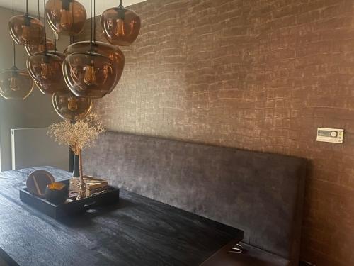 a dining room with a table and a brick wall at Ruime woning met jacuzzi, 10 min van strand in Lisse