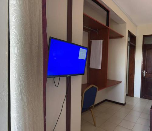 a tv on a wall in a room at Hotel Royal Nest Entebbe in Entebbe
