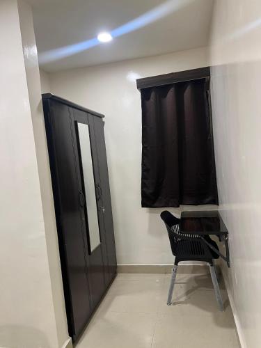 a black cabinet and a black chair in a room at Hotel Abhimanyu Villa in Hyderabad
