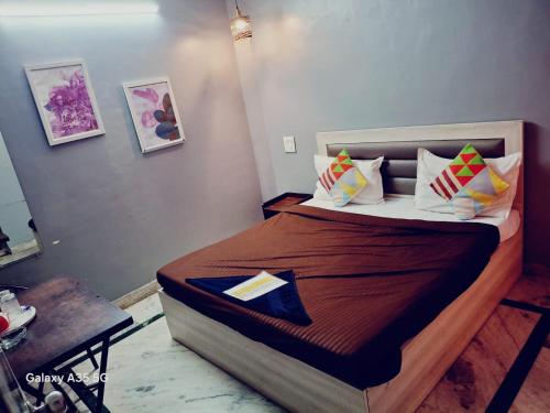 a bedroom with a bed with pillows and a table at Hotel Nebula Grand in Panvel