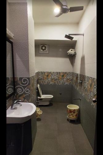 a bathroom with a sink and a toilet at Baba Palace - A Heritage Hotel, Udaipur in Udaipur