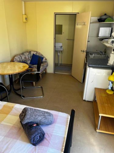 a room with a kitchen with a table and a couch at Longreach Caravan and Cabin Park in Longreach