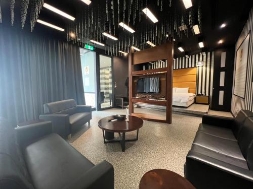 a living room with couches and a bed and a table at 九號行館No9 Hotel in Changhua City