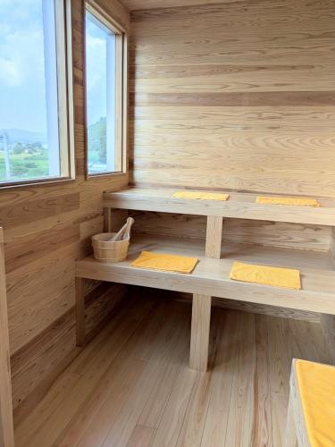 a sauna with two benches in a wooden wall at 南阿蘇サウナ5gaku G1 in Minami Aso