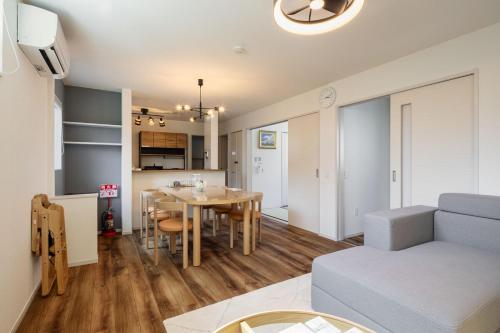 a living room and kitchen with a table and a couch at Fukuoka Airport 6 in Shime