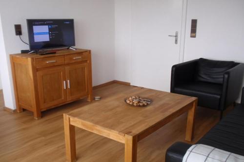 a living room with a coffee table and a television at Villa Hochwald Familienhaus in Geisfeld