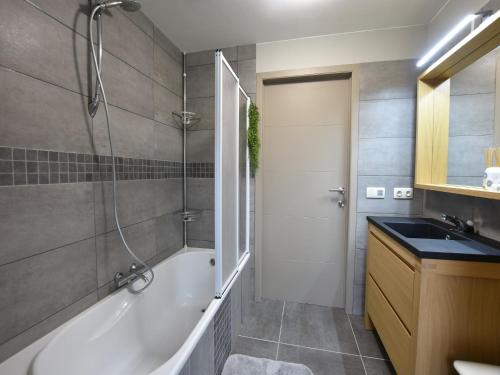 a bathroom with a tub and a shower and a sink at Holiday Home in Alveringem near Beach in Alveringem