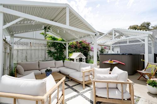 a patio with white furniture under a white pergola at Spacious Hamptons-style home with plunge pool in Saint Leonards