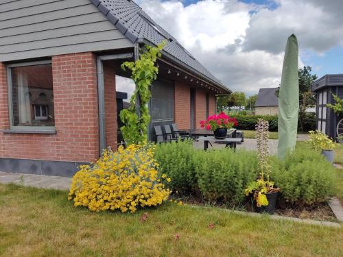 a garden with flowers and plants in front of a house at Holiday Home in Alveringem near Beach in Alveringem