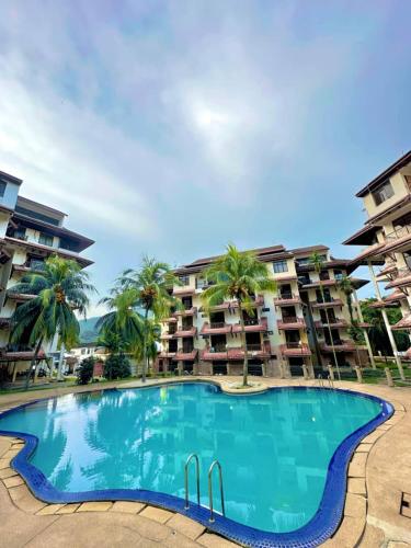 a swimming pool in front of some apartment buildings at AzYaa Homestay in Langkawi Islands
