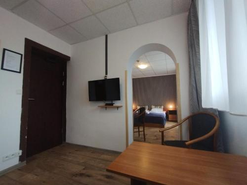 a room with a dining table and a bedroom at Ośrodek Wypoczynkowy Zapalenica in Szczyrk