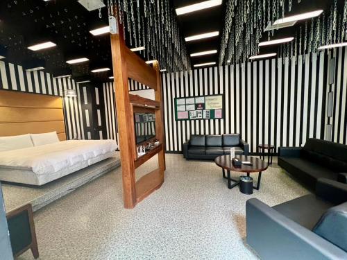 a bedroom with a bed and a couch and a table at 九號行館No9 Hotel in Changhua City