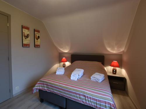 a bedroom with a bed with two towels on it at Holiday Home in Alveringem near Beach in Alveringem