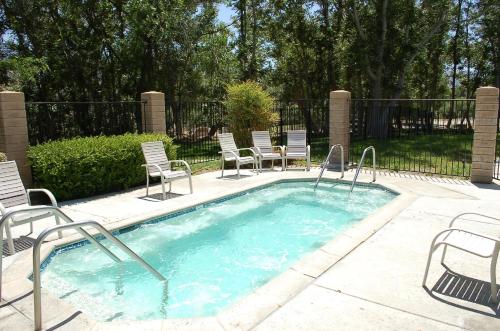 una pequeña piscina con sillas y una valla en Soledad Canyon Cabin 18 en Ravenna