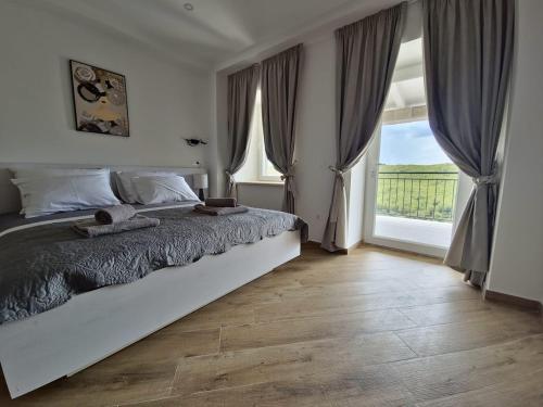 a bedroom with a bed and a large window at New Villa Penelopa in Babino Polje