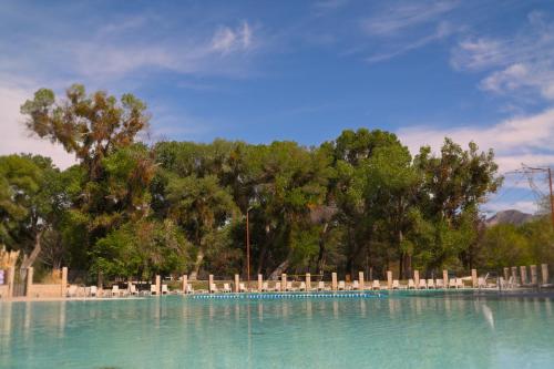 a swimming pool with chairs and trees in the background at Soledad Canyon Studio Cabin 21 in Ravenna