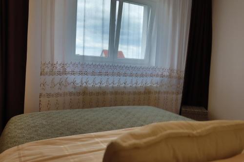 a bedroom with a bed and a window at Lilo HOME in Sibiu