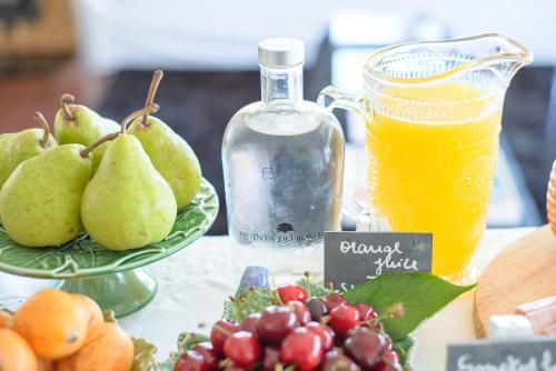 a table with a plate of pears and a bottle of juice at Quinta Do Bosque in Mesão Frio
