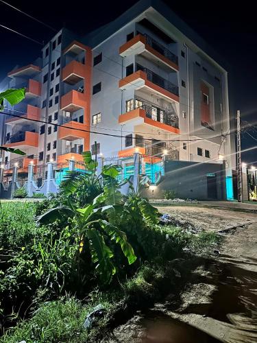 a building at night with a plant in front of it at Résidence Prestige KGV in Douala