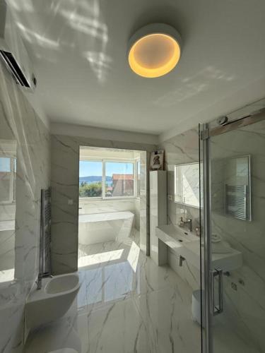 a bathroom with a tub and a toilet and a sink at Vila Sunset in Kaštela