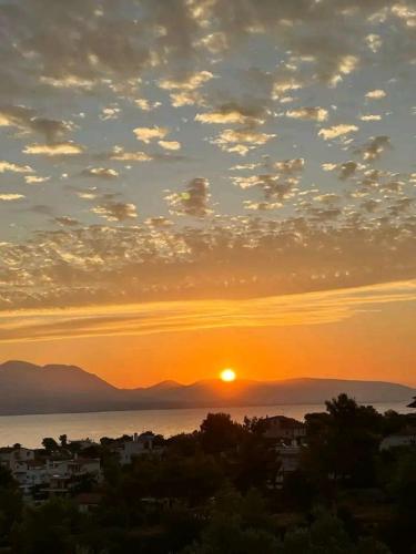 a sunset over the water with a city at Sea view house I in Dhílesi