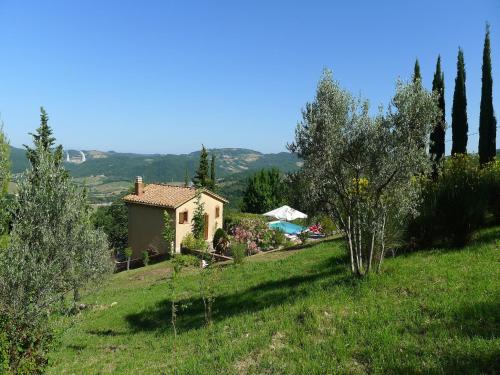 a small house on top of a green field at Villa in Sasso Pisano wuith garden in Sasso Pisano