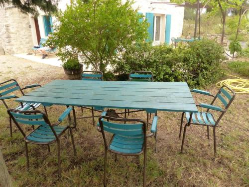 a blue picnic table and chairs in the grass at Le camberaud in Mailhac