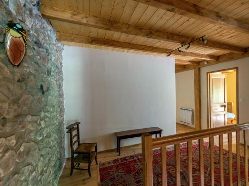 a room with a table and a stone wall at Secluded Stone Villa Retreat in Saint-Bonnet-le-Froid