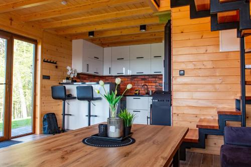a kitchen in a log cabin with a wooden table at Ranczo pod laskiem 