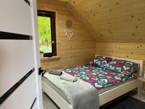 a bedroom with a bed in a wooden cabin at Ranczo pod laskiem 