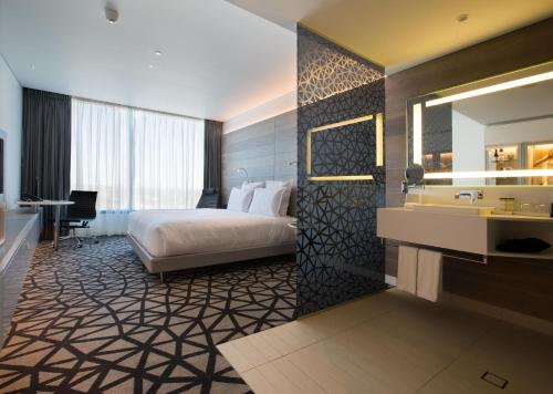 a hotel room with a large bed and a large mirror at Pullman Sydney Airport in Sydney