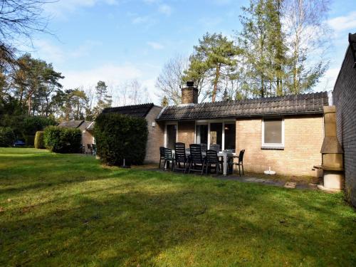 a house with chairs and a table in the yard at Holiday Home in Lochem near Forest Trails in Lochem