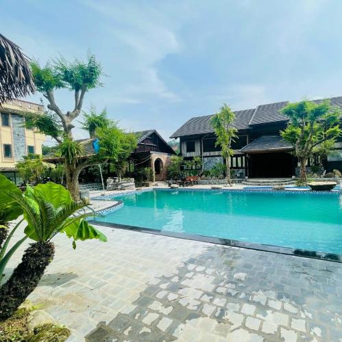 a large swimming pool in front of a house at HaGiang Go Ecolodge in Làng Lap
