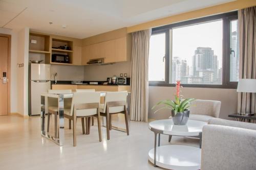 a kitchen and living room with a table and chairs at Seda Bonifacio Global City in Manila