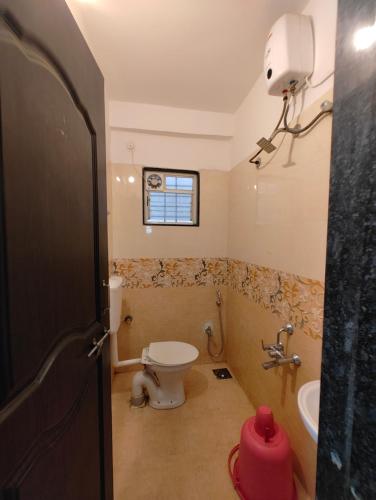 a bathroom with a toilet and a sink at Hotel Arrow Residency in Pune