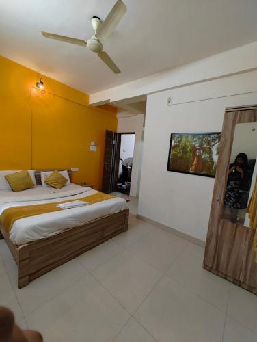 a bedroom with a bed and a ceiling fan at Hotel Arrow Residency in Pune