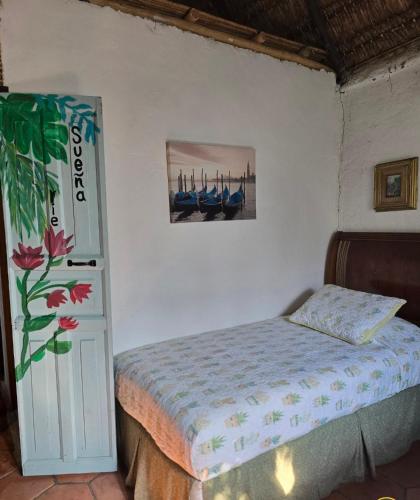 a bedroom with a bed and a picture on the wall at Cabañas Mannan in Tanchachín