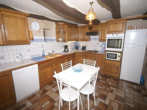 a kitchen with a white table and white appliances at Holiday Home in Muret near Château Colombier in Muret-le-Château